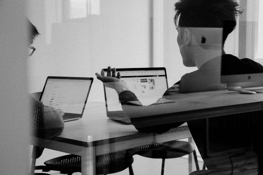 Zwei Personen bei der Arbeit an Laptops