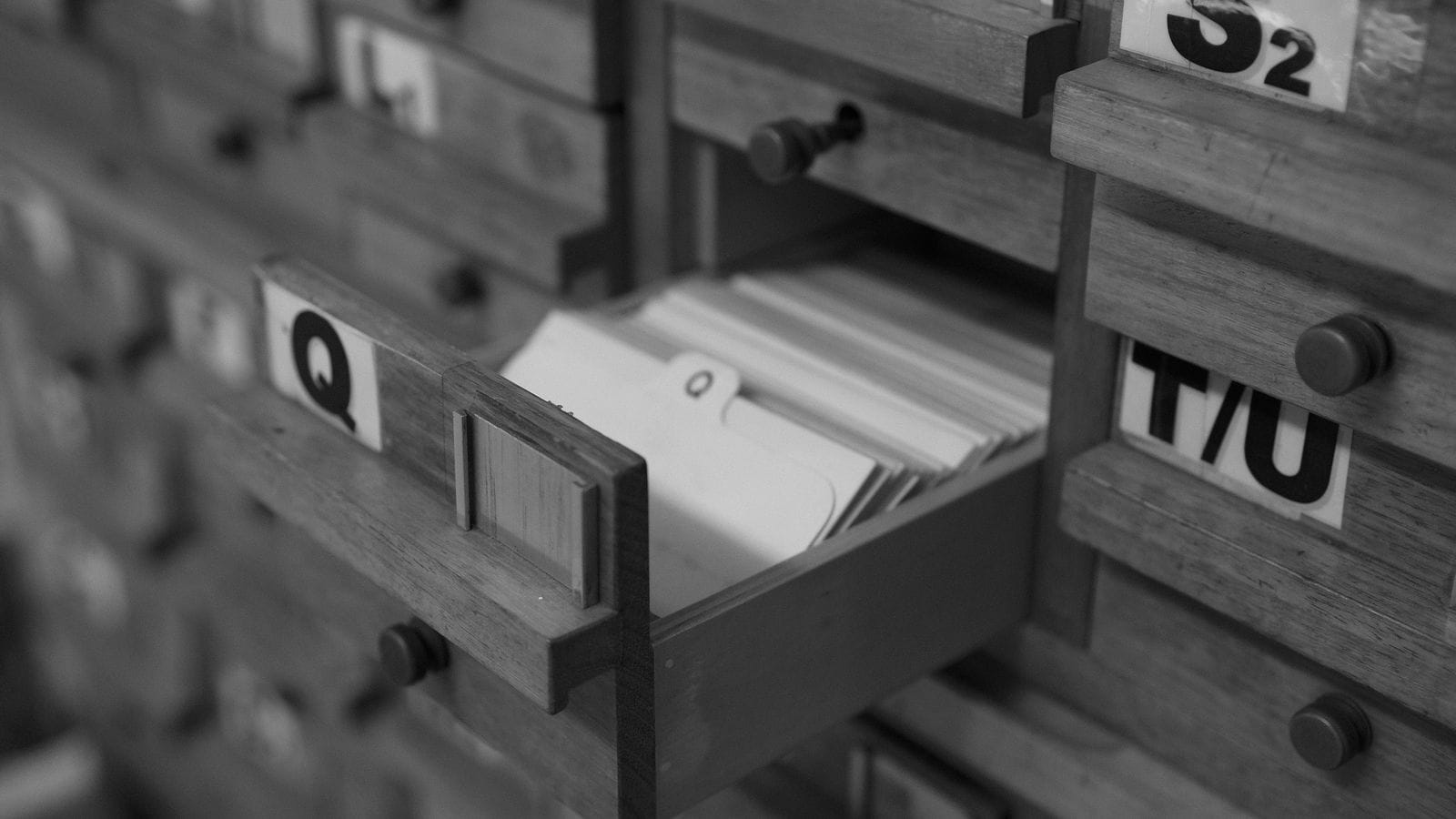 Geöffnete Karteischublade in einem Bibliothekskatalog mit Buchstabenregistern, schwarzweiß - Sinnbild für nach Themen geordnete Suchanfragen