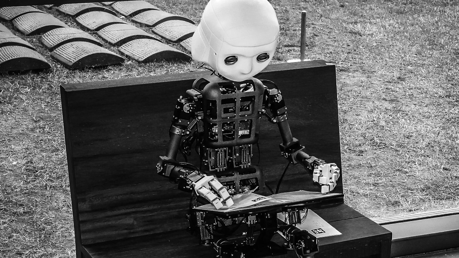 Humanoider Roboter auf einer Bank, der eine Zeitschrift liest - Sinnbild für Suchagenten, die Inhalte selbst auswerten