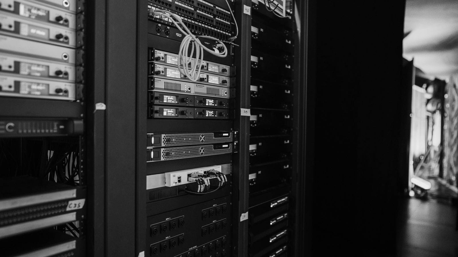 Server-Racks mit Netzwerkkabeln in einem Serverraum, schwarzweiß
